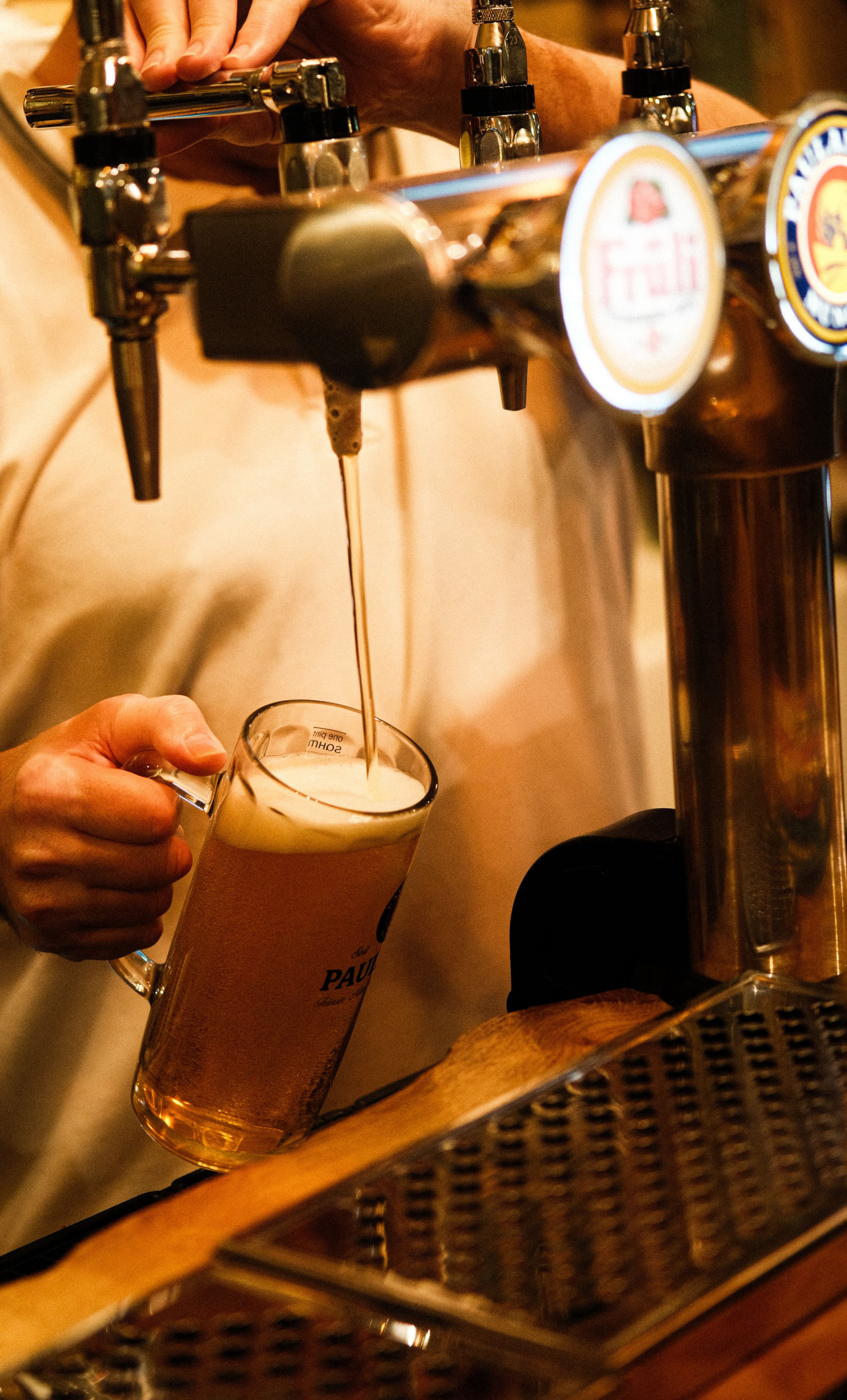 A pint of paulaner being poured from a draught tap